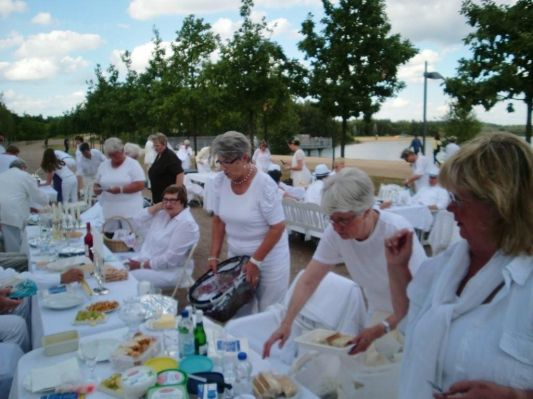 Marga und die beiden Christels sind fleißig beim Aufbauen. Ingrid sitzt bereits und hofft, dass es bald los geht.