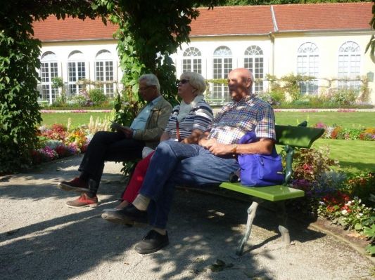 Manfred, Christel und Dieter ruhen sich vor der Orangerie aus